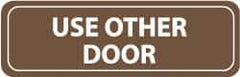 NMC - Use Other Door, 11" Wide x 3.5" High, Acrylic Sign - English, White on Brown, Wall Mount - USA Tool & Supply